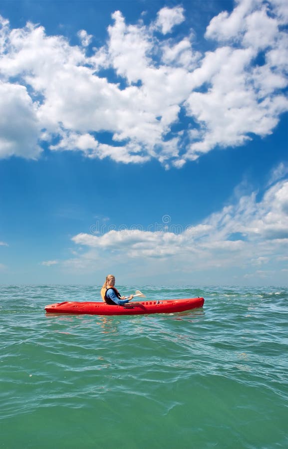Young man in sea kayak under dramatic skies