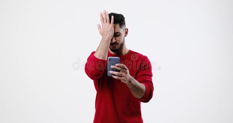 Young man shaking head while using mobile phone stock video footage