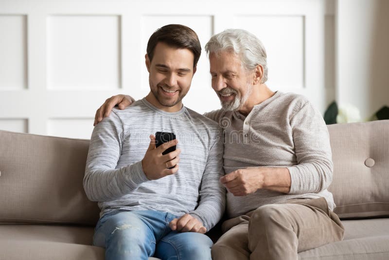 Young Man Showing Funny Video on Smartphone To Happy Father. Stock Image -  Image of phone, elderly: 172733813