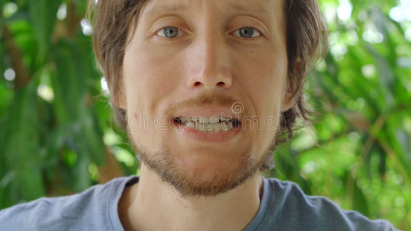 Young man shows a mouth guard for protecting teeth against abrasion