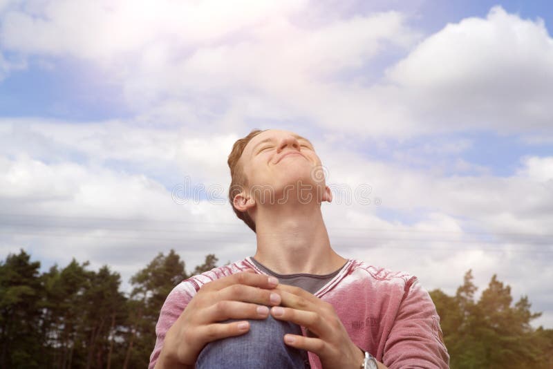 Young man sitting outdoors and enjoying the sun royalty free stock images Young man sitting outdoors and enjoying the sun royalty free stock images