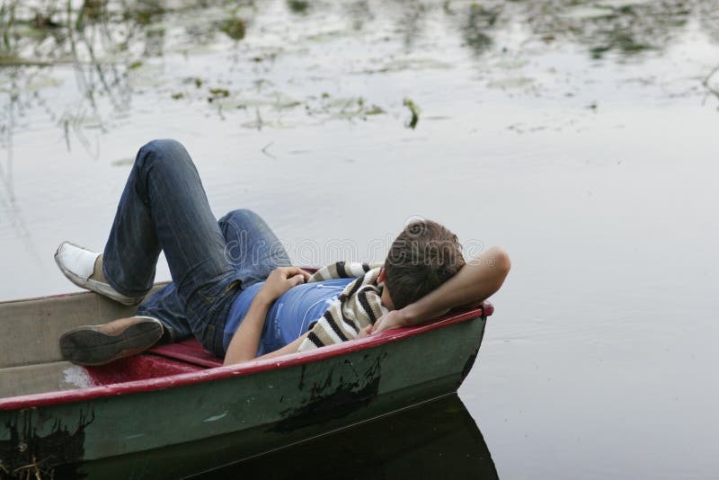 Young man sleeping on boat stock image. Image of board 