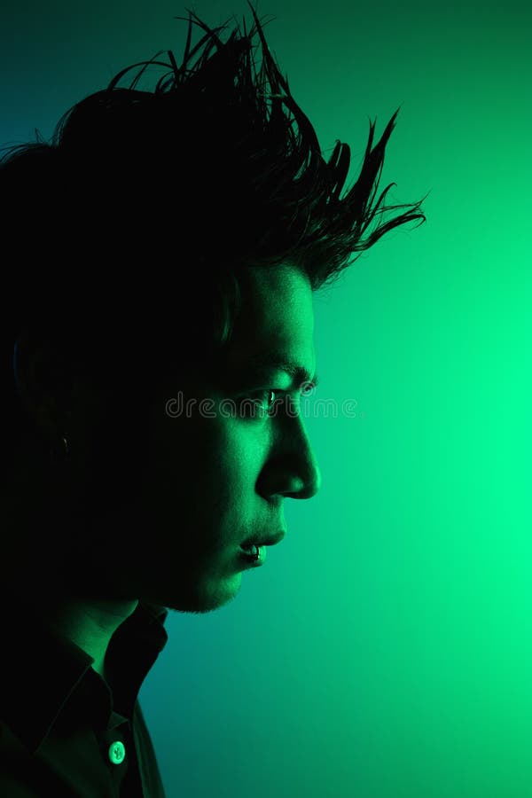 Side view of attractive young Asian man with spiked hair. Side view of attractive young Asian man with spiked hair.
