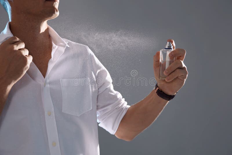 Young man spraying perfume stock photo. Image of applying - 130683712