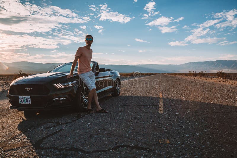 Young man standing by the Ford Mustang GT royalty free stock images Young man standing by the Ford Mustang GT royalty free stock images