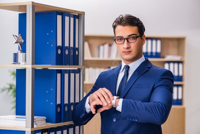 The young man standing next to the shelf with folders. Executive, business.