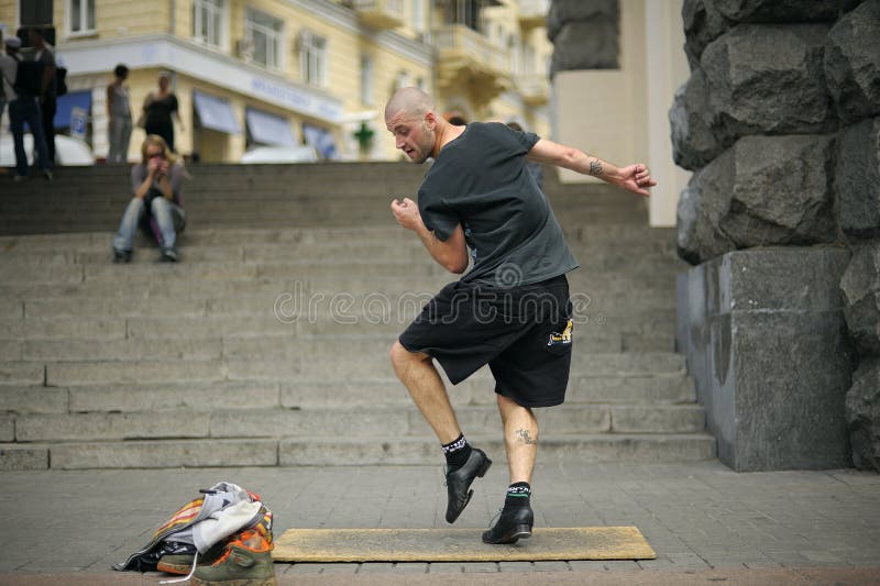 Young man, street dancer, performing tap dance on the pavement