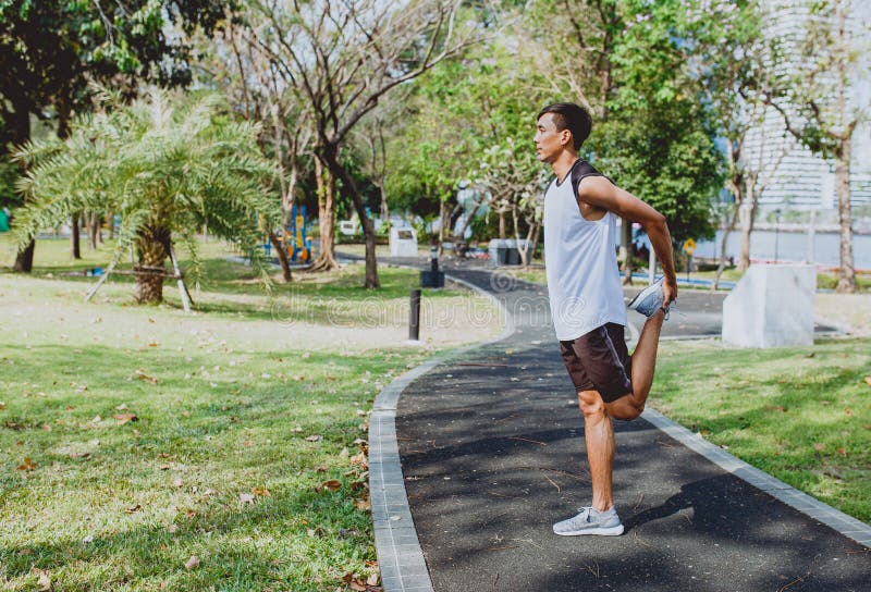 Young man stretching bodies, warming up for jogging stock photo Young man stretching bodies, warming up for jogging stock photo