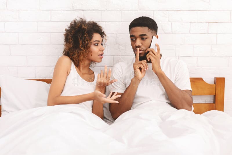 Young Man Talking on Cellphone, Ignoring His Young Hot Wife Stock Image