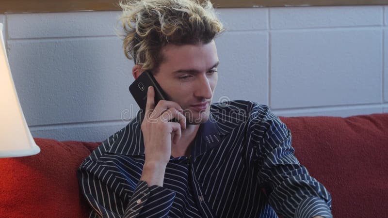 Young man talking on the phone at home