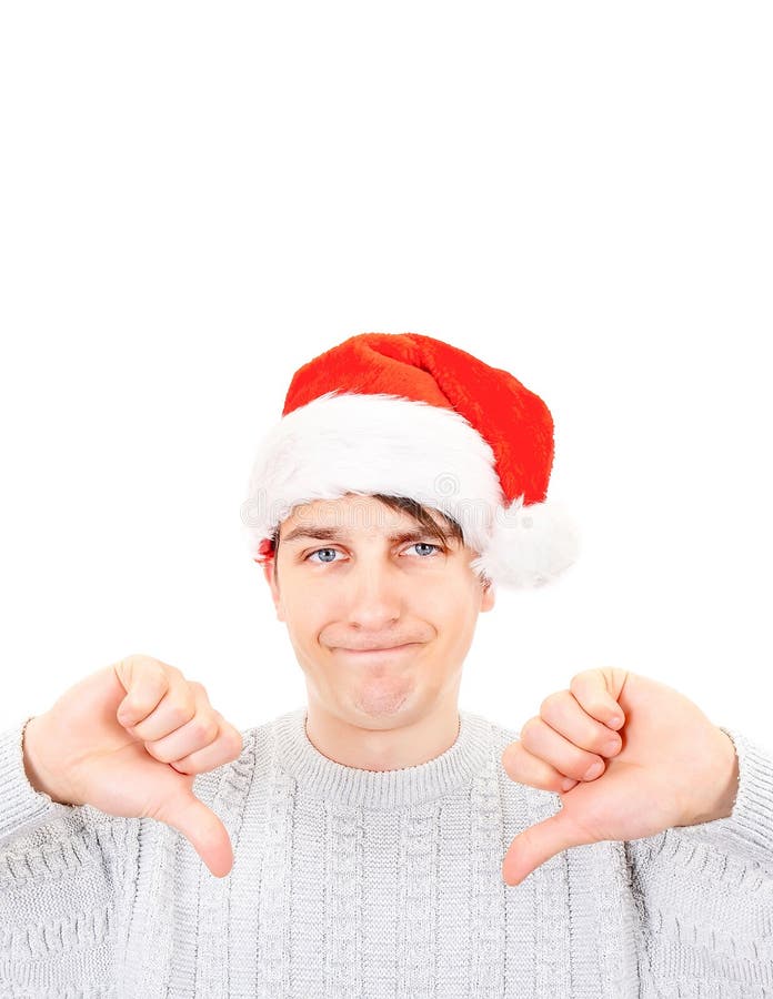 Sad Young Man in Santa Hat make Thumbs Down on the White Background closeup. Sad Young Man in Santa Hat make Thumbs Down on the White Background closeup