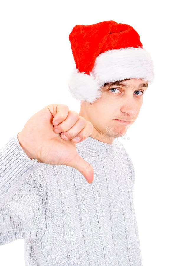 Unhappy Young Man in Santa Hat make Thumb Down on the White Background. Unhappy Young Man in Santa Hat make Thumb Down on the White Background