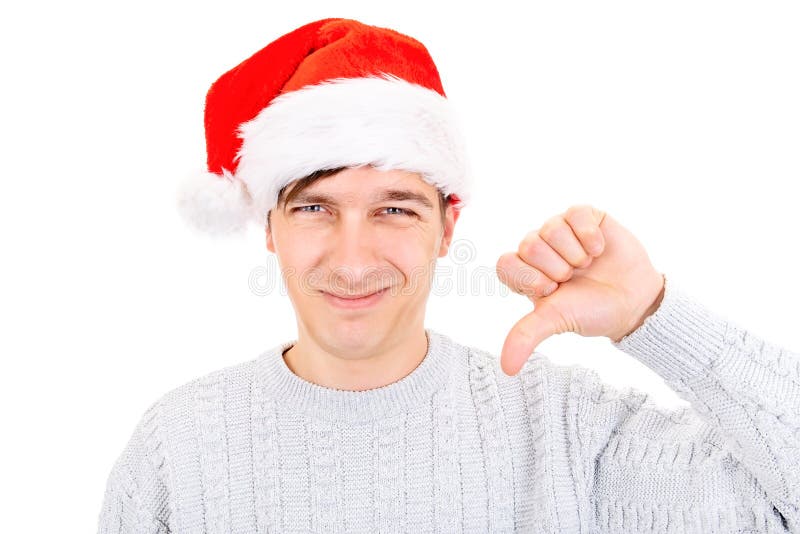 Unhappy Young Man in Santa Hat make Thumb Down on the White Background. Unhappy Young Man in Santa Hat make Thumb Down on the White Background