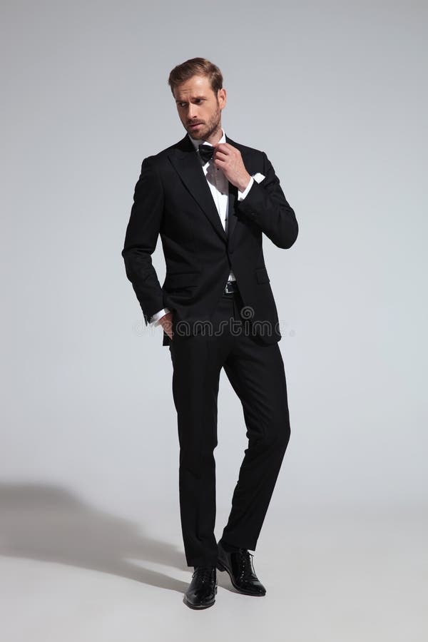 Man in Tuxedo Fixing His Bowtie and Looks To Side Stock Photo - Image ...