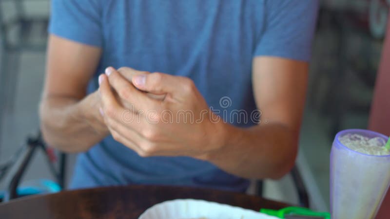 Young man use a hand sanitizer in a cafe