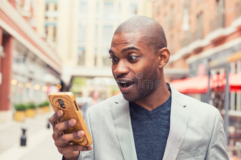 Young man using smart phone. Businessman holding mobile smartphone using app texting sms message wearing jacket