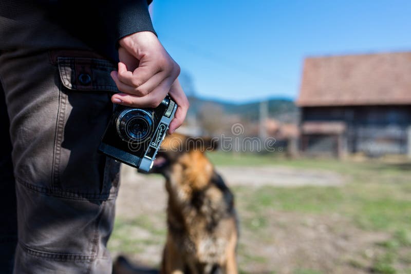 Young man using vintage russian camera, sitting german shepherd in front of him. stock images Young man using vintage russian camera, sitting german shepherd in front of him. stock images