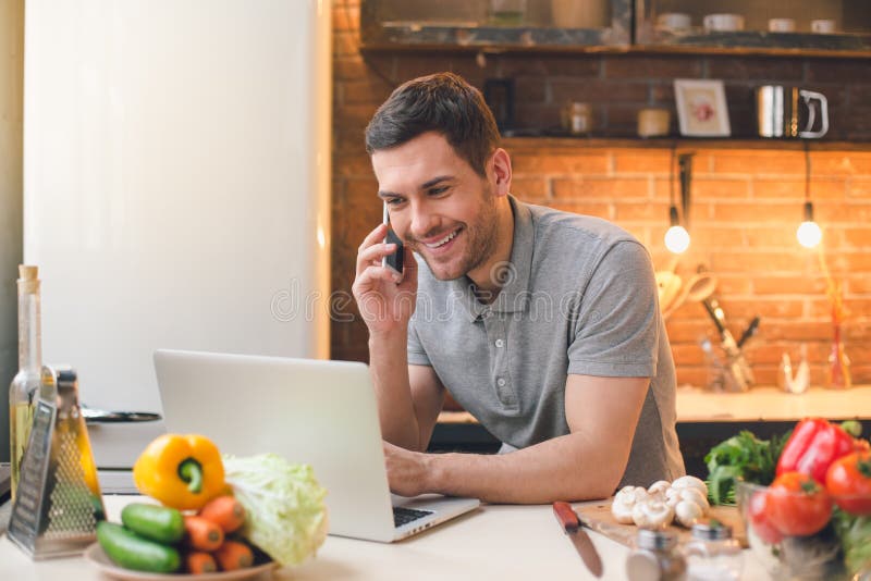 Young Man Vegan Meal Preparation Using Laptop royalty free stock photo Young Man Vegan Meal Preparation Using Laptop royalty free stock photo