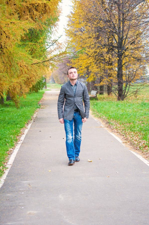 Young Man Walking in Autumn Park Stock Photo - Image of fashion