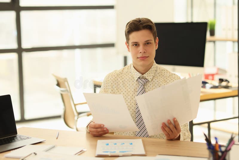 The Young Man Watches Documents in the Office, Closeup Stock Image