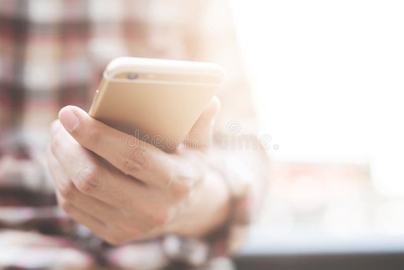 Young man wear plaid shirt. close up hand using on cell phone during rest on sofa. sitting in watching message on mobile smart ph stock photo