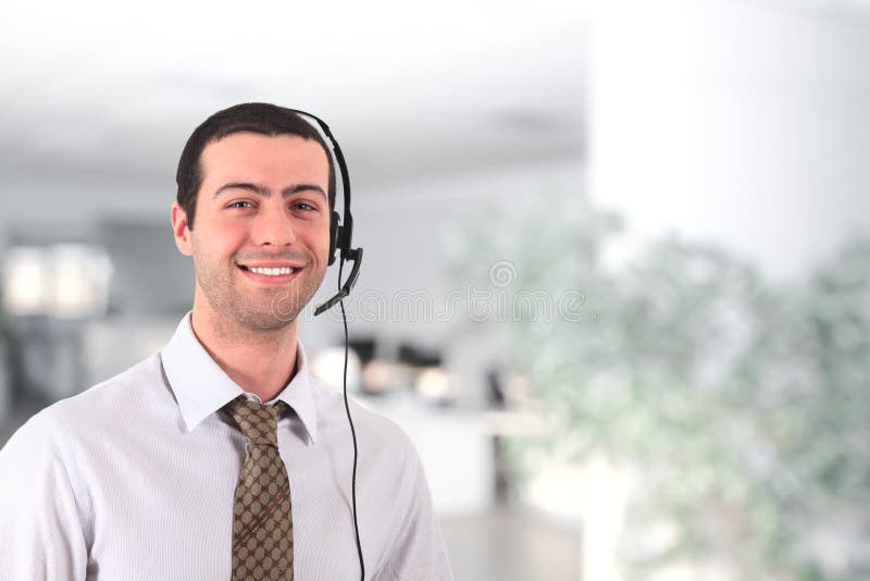 Handsome smiling young man wearing an headset. Handsome smiling young man wearing an headset