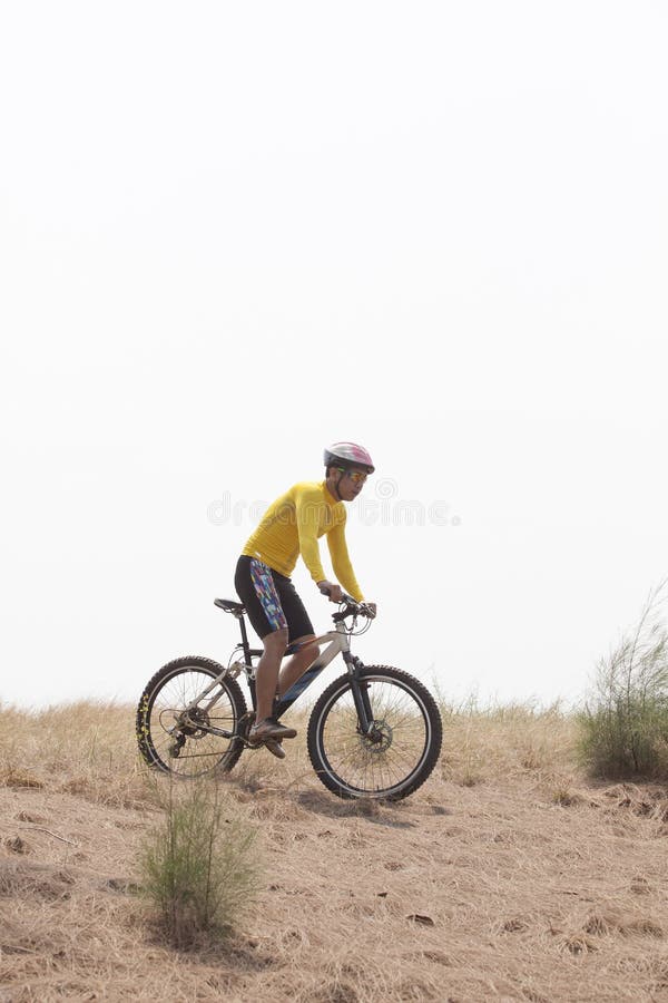 Young man wearing rider suit riding mountain bike MBT on dusty road use for sport activities and male outdoor sport