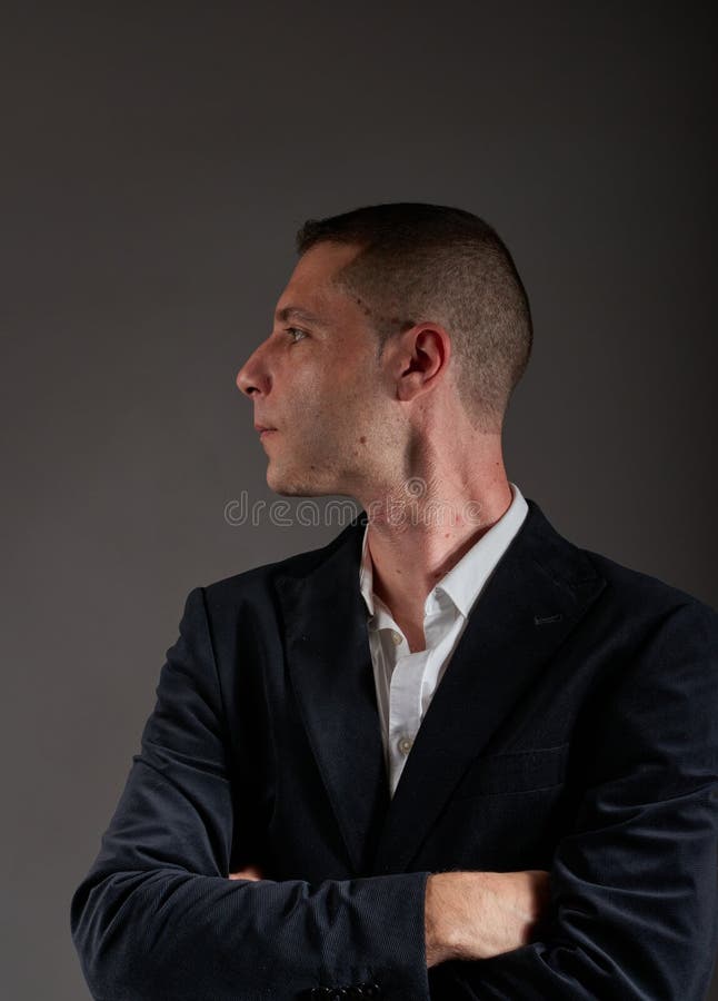 A Young Man Wearing a White Shirt and a Black Jacket Stock Photo
