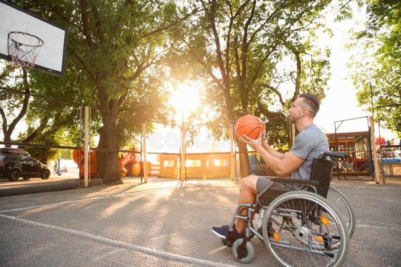 Young Man in Wheelchair Playing Basketball Outdoors Stock Photo Image