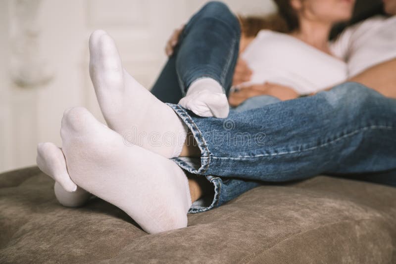 Child with bare feet in jeans. Lying on the bed. Foot barefoot Stock Photo