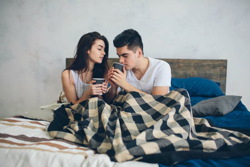 A Young Man and a Woman are Drinking Coffee in the Morning in Bed ...