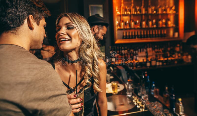 Loving young couple at club. Young men and women having good time at nightclub. Loving young couple at club. Young men and women having good time at nightclub.