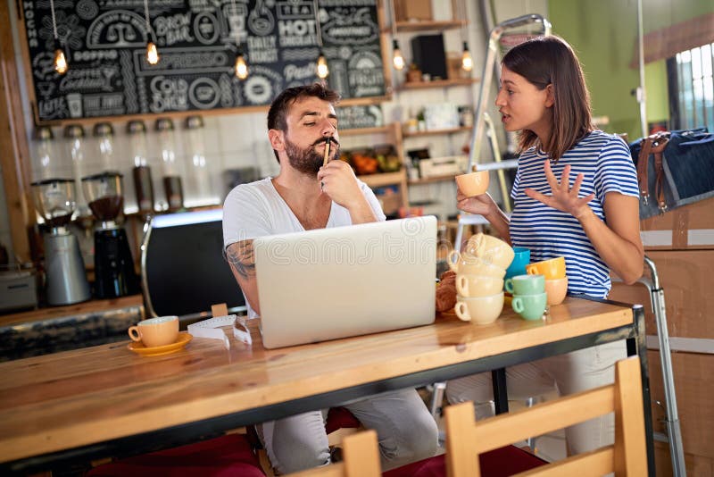 Young man and woman with laptop ready to open their cafe.Small business owner stock photography Young man and woman with laptop ready to open their cafe.Small business owner stock photography