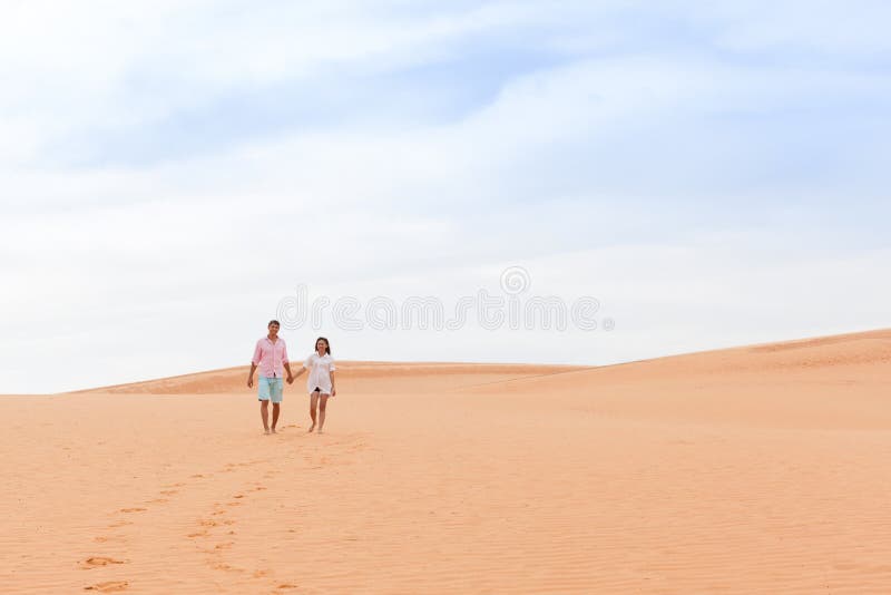 Young Man Woman Walking In Desert Couple Girl And Man Hold Hands Sand Dune Landscape