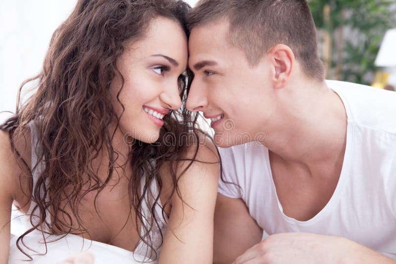 Young man and women in love lying on the bed