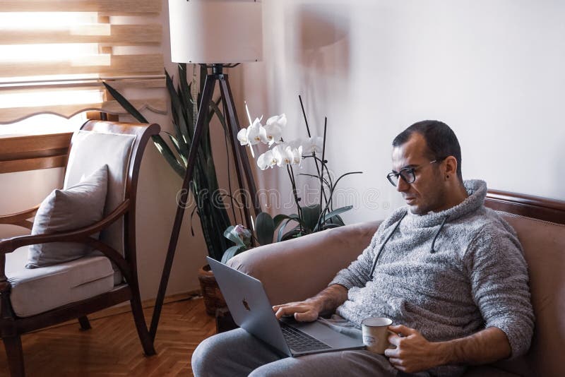 Young man working as home office which is getting popular all around the world. Working with a cup of coffee with your notebook on