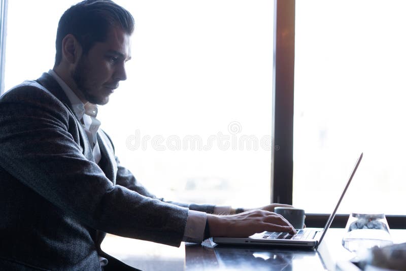 Young man working on his laptop in a coffee shop, rear view of business man hands busy using laptop at office desk. royalty free stock photo Young man working on his laptop in a coffee shop, rear view of business man hands busy using laptop at office desk. royalty free stock photo