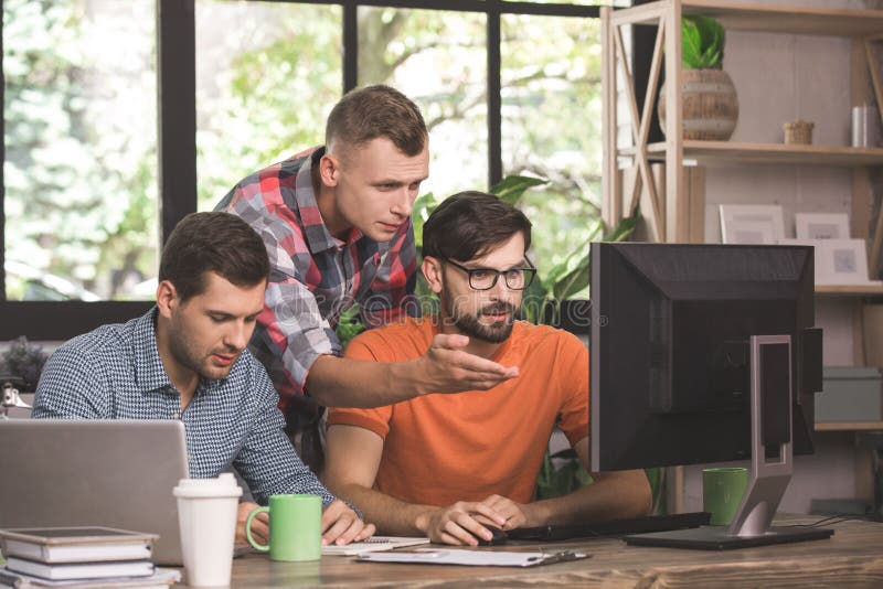 Young men programmers working together in the office royalty free stock image Young men programmers working together in the office royalty free stock image