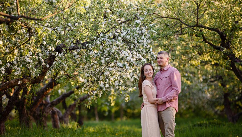 Young man and woman couple in a blooming apple garden