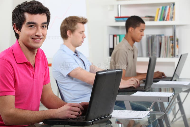 Young men working on their assignments in a computer lab. Young men working on their assignments in a computer lab