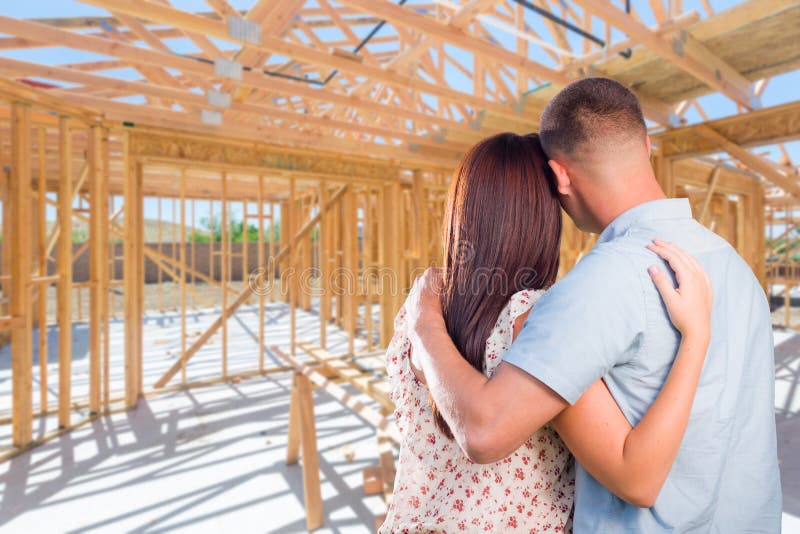 Young Military Couple On Site Inside Their New Home Construction
