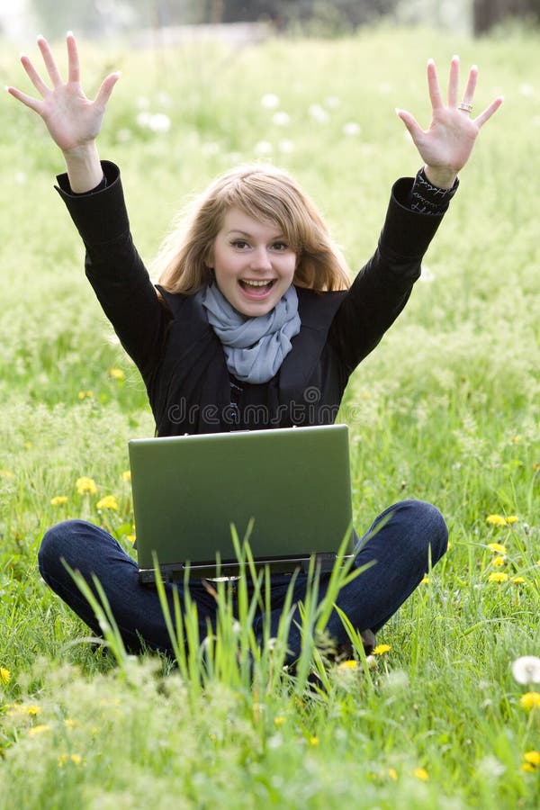 Young model with laptop on green grass