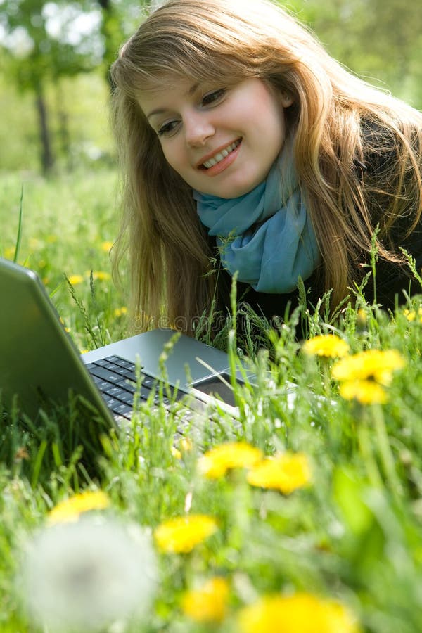 Young model with laptop on green grass