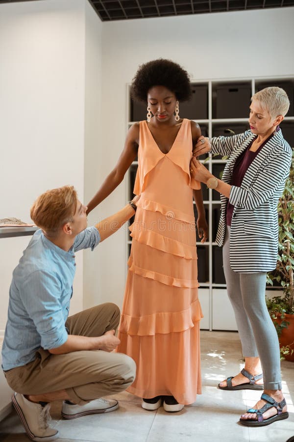 Young model standing next to two fashion designers stock photo Young model standing next to two fashion designers stock photo
