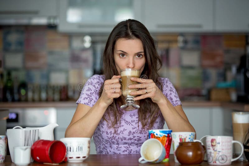 Young Mom, Drinking Many Coffees in the Morning with Her Toddler Child ...