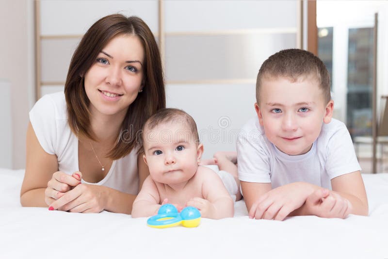 Mother And Her Two Sons Are Sitting On A Couch Stock Photo Image Of