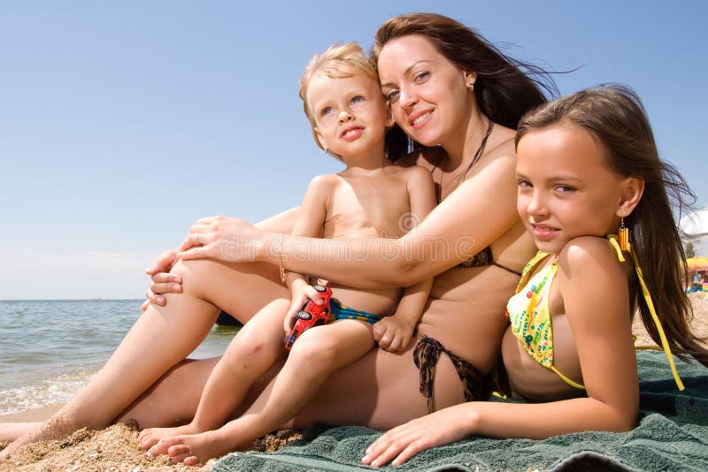 Young mom with kids at the beach resort