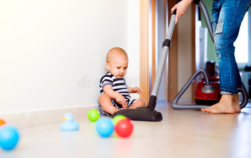 Young mother with a baby boy doing housework.