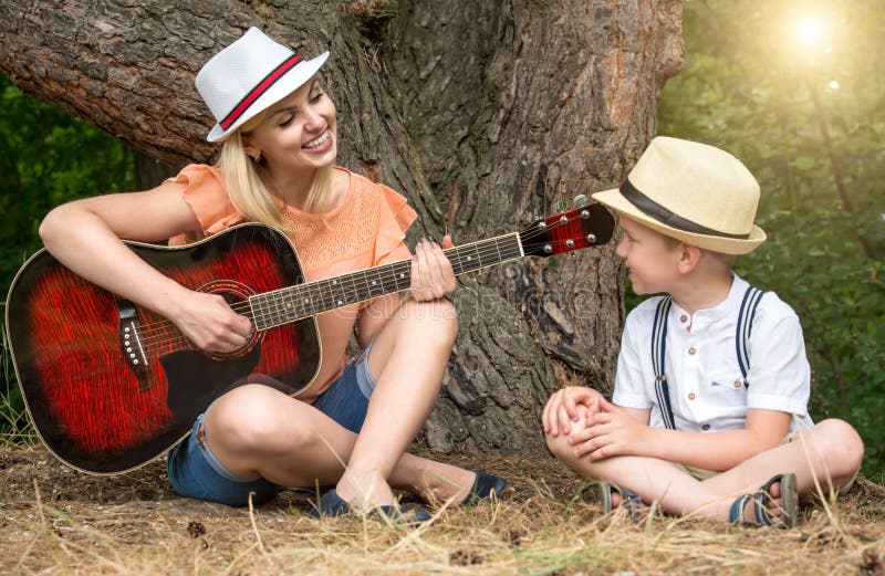 Young Mother and Beautiful Son Rest in the Forest,sing Songs Under a ...