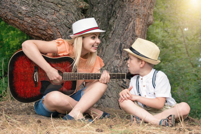 Young Mother and Beautiful Son Rest in the Forest,sing Songs Under a ...